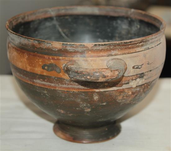A Greek black slip decorated skyphos, Apulia, c.4th century BC, 22.5cm, broken and re-assembled